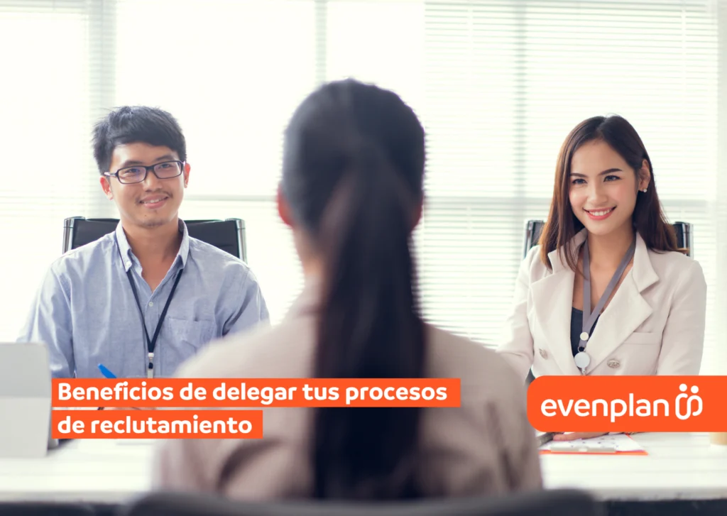 Three professionals in a bright office interview setting; two recruiters facing a candidate viewed from behind, with an orange recruitment banner across the bottom right and left.